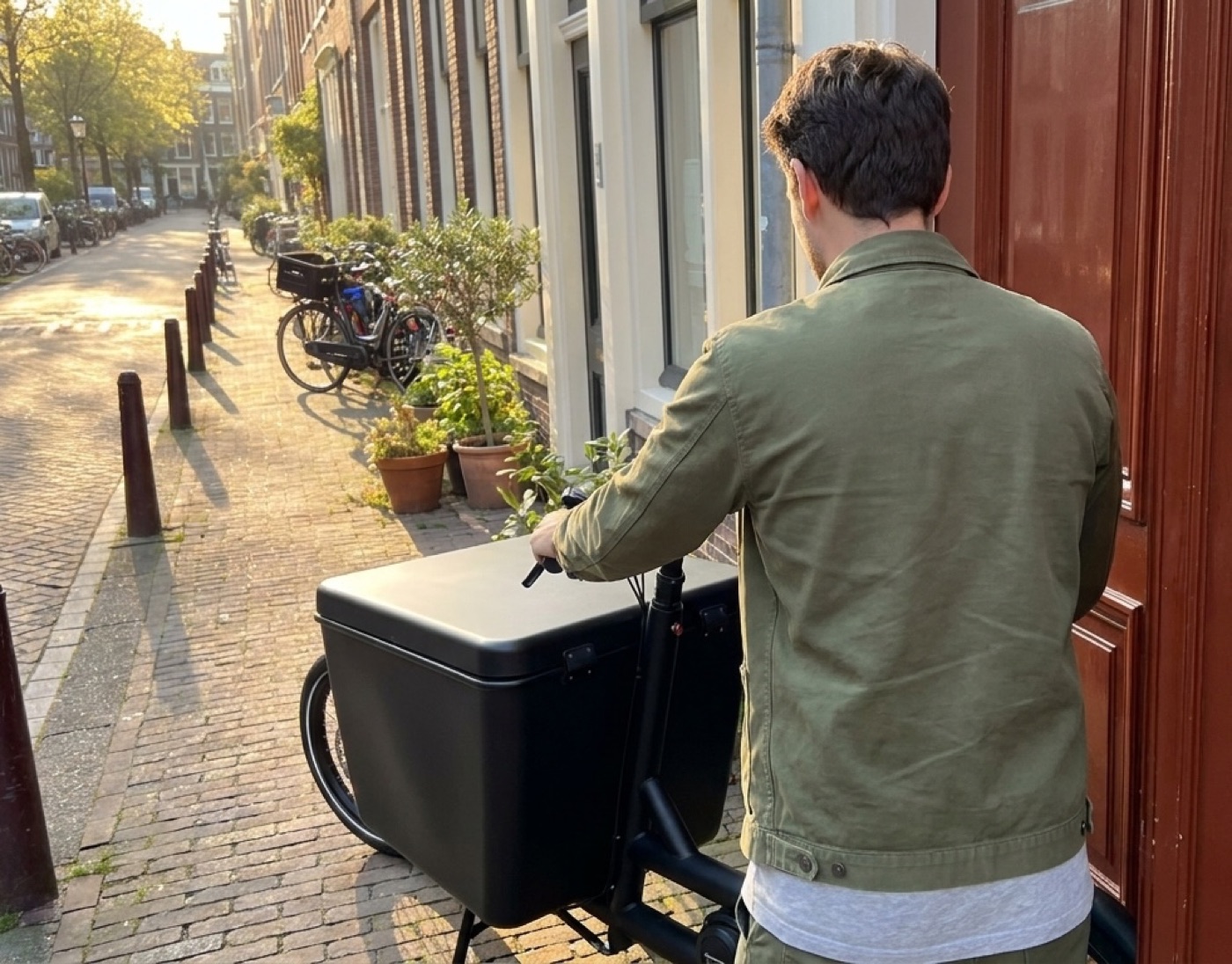 Slotenmaker met zijn bakfiets bij een voordeur in Amsterdam